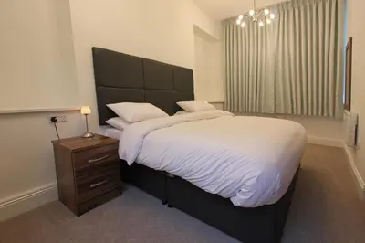 a bedroom with a large bed and a night stand at The Castle Collection 14 Cook Street in Liverpool