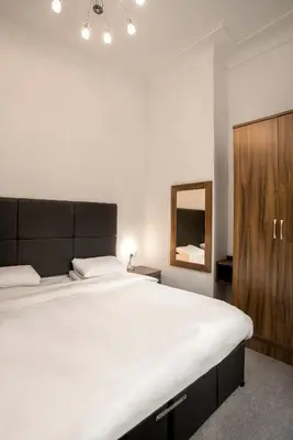 a bedroom with a large bed and a wooden cabinet at The Castle Collection 14 Cook Street in Liverpool