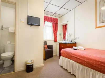 a hotel room with a bed and a toilet at Oak Lea Hotel in Blackpool