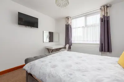 a bedroom with a large bed and a television at Beachcliffe Lodge Apartments in Blackpool