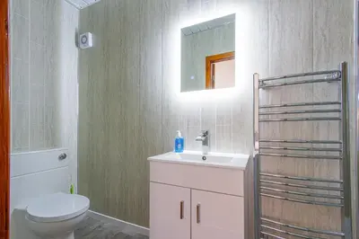 a bathroom with a sink and a toilet and a mirror at Beachcliffe Lodge Apartments in Blackpool