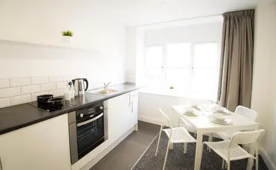 a kitchen with a table and a table and chairs at Fox Street Apartments in Liverpool