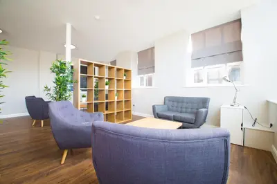 a living room with two blue chairs and a table at Fox Street Apartments in Liverpool