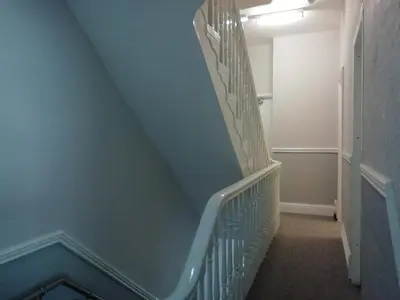 a staircase with blue walls and white railings at The Shining Diamond in Blackpool