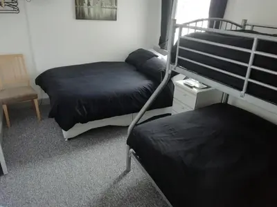 a bedroom with two bunk beds and a chair at The Shining Diamond in Blackpool