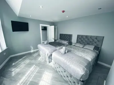 a bedroom with two beds and a flat screen tv at Brownlows Inn in Liverpool