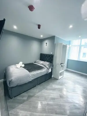a bedroom with a bed and a refrigerator at Brownlows Inn in Liverpool