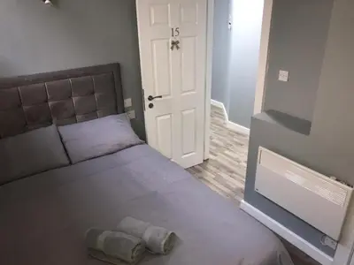 a bedroom with a large bed and a white door at Brownlows Inn in Liverpool