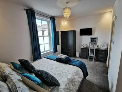 a bedroom with a bed and a couch and a window at Saracens House in Preesall