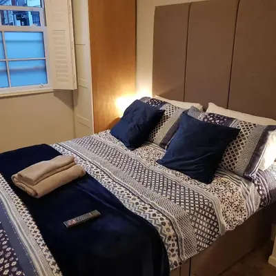 a bed with blue and white sheets and pillows at Saracens House in Preesall