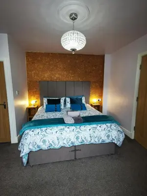a bedroom with a large bed with blue pillows at Saracens House in Preesall