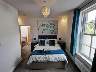 a bedroom with a large bed with blue curtains at Saracens House in Preesall