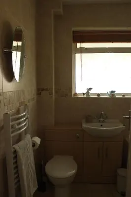 a bathroom with a toilet and a sink and a window at Dolphin House in Preesall