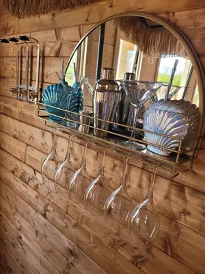 a shelf with wine glasses and a mirror at Dolphin House in Preesall