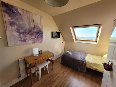 a bedroom with a desk and a bed and a window at Dolphin House in Preesall
