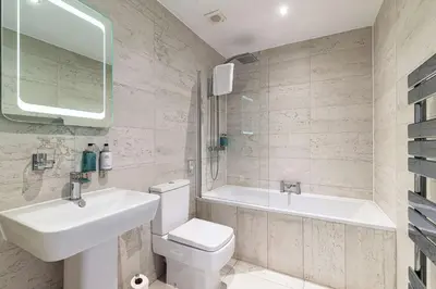 a bathroom with a sink and a toilet and a tub at The Bold Hotel; BW Signature Collection in Southport
