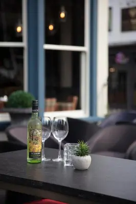 a bottle of wine sitting on a table with two wine glasses at The Bold Hotel; BW Signature Collection in Southport