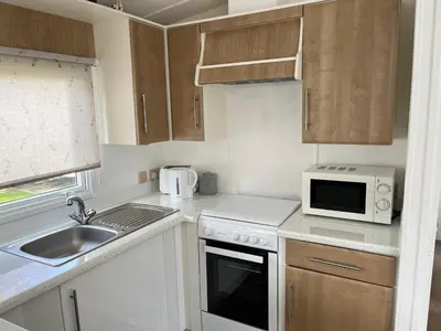 a small kitchen with a sink and a microwave at Family Holidays Blackpool in Blackpool
