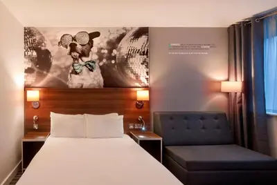 a bed and a chair in a hotel room at Heeton Concept Hotel - City Centre Liverpool in Liverpool