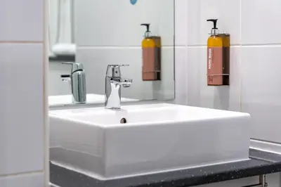 a bathroom with a white sink and a mirror at Heeton Concept Hotel - City Centre Liverpool in Liverpool