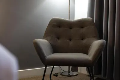 a brown chair sitting in a room next to a window at Heeton Concept Hotel - City Centre Liverpool in Liverpool