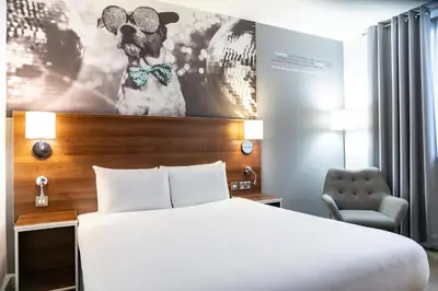 a hotel room with a bed and a picture of a dog at Heeton Concept Hotel - City Centre Liverpool in Liverpool