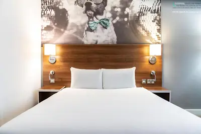 a bedroom with a bed and a picture of a dog at Heeton Concept Hotel - City Centre Liverpool in Liverpool