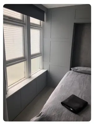 a bedroom with a bed and two windows at The Elk in Blackpool