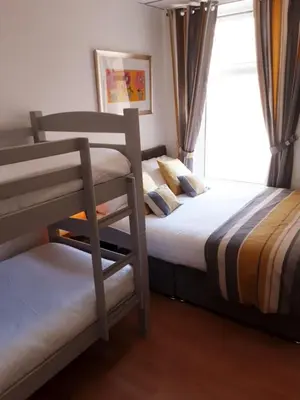 a bedroom with two bunk beds and a window at The Cardoun in Blackpool