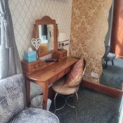 a dressing table with a mirror and a chair at Tracey's Driftwood in Blackpool