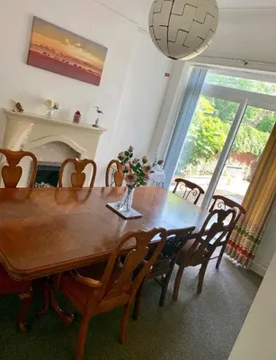 a dining room with a table and chairs and a fireplace at Beach house in Crosby