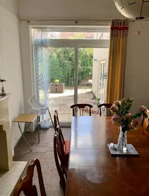 a dining room with a table and a large window at Beach house in Crosby
