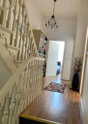 a white staircase in a house with a hallway at Beach house in Crosby