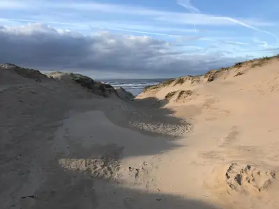 a puddle of water in the sand on a beach at Beach house in Crosby