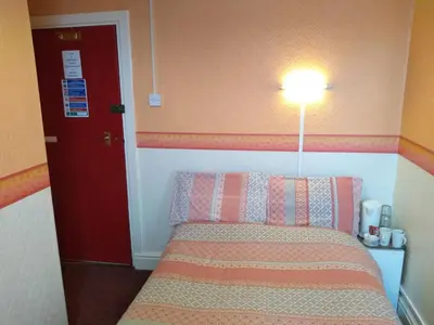 a bedroom with a bed with a red door and a lamp at Southview Hotel in Blackpool