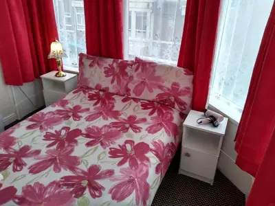 a bedroom with a bed with pink flowers on it at Southview Hotel in Blackpool
