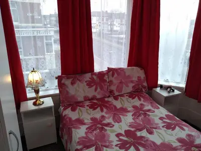 a bedroom with a bed and a window with red curtains at Southview Hotel in Blackpool