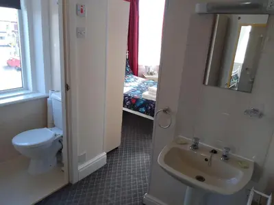 a bathroom with a sink and a toilet and a window at Southview Hotel in Blackpool
