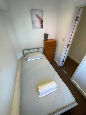 a small bedroom with two beds and a dresser at 2 Laurel Court in Ulverston