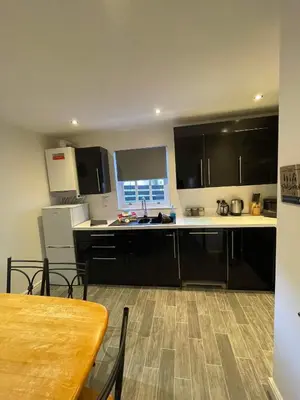 a kitchen with black cabinets and a wooden table at 2 Laurel Court in Ulverston