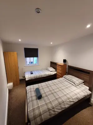 a bedroom with two beds and a television in it at 3 Laurel Court in Ulverston