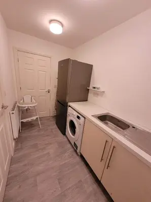 a small kitchen with a refrigerator and a sink at 3 Laurel Court in Ulverston
