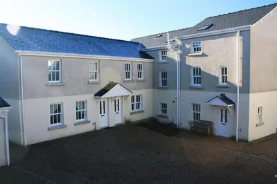 two buildings with white doors and a courtyard at 4 Laurel Court in Ulverston