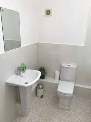 a bathroom with a sink and a toilet and a mirror at 4 Laurel Court in Ulverston