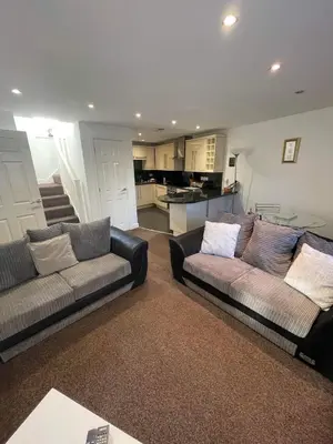 a living room with two couches and a kitchen at 4 Laurel Court in Ulverston