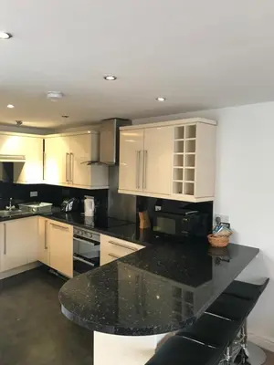 a kitchen with white cabinets and a black counter top at 4 Laurel Court in Ulverston