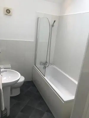 a bathroom with a shower and a toilet and a sink at 5 Laurel Court in Ulverston