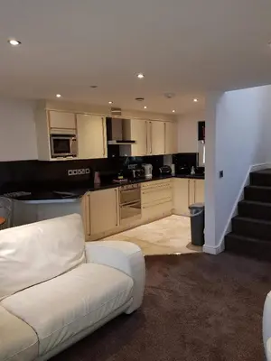 a living room with a white couch and a kitchen at 5 Laurel Court in Ulverston