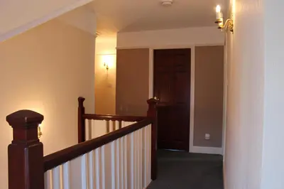 a hallway with a staircase with a wooden door at Wyndcliffe in Grange Over Sands