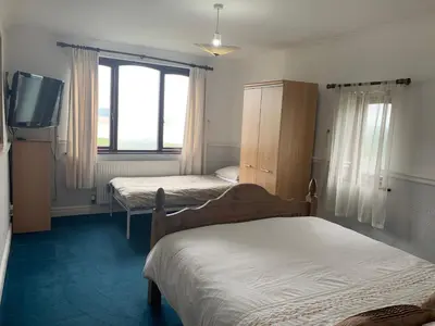 a bedroom with two beds and a tv in it at Wyndcliffe in Grange Over Sands